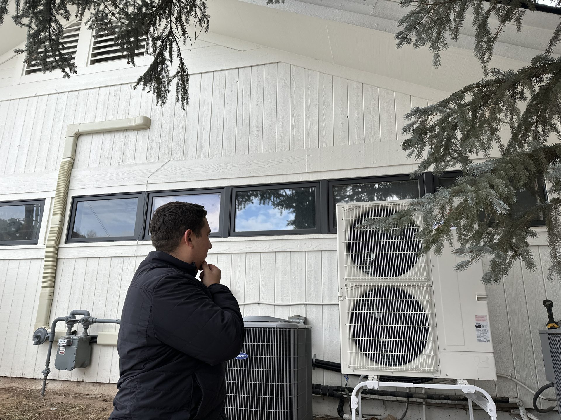 Elite Hvac Contractor In front of a heat pump and traditional a/c system